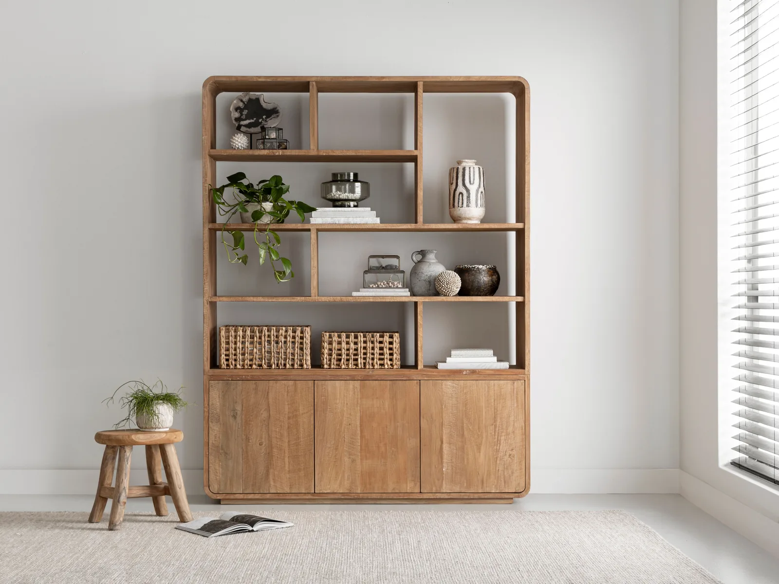 Boekenkast Nova klein in een lichte woonkamer met decoratie en een krukje - DTP Home