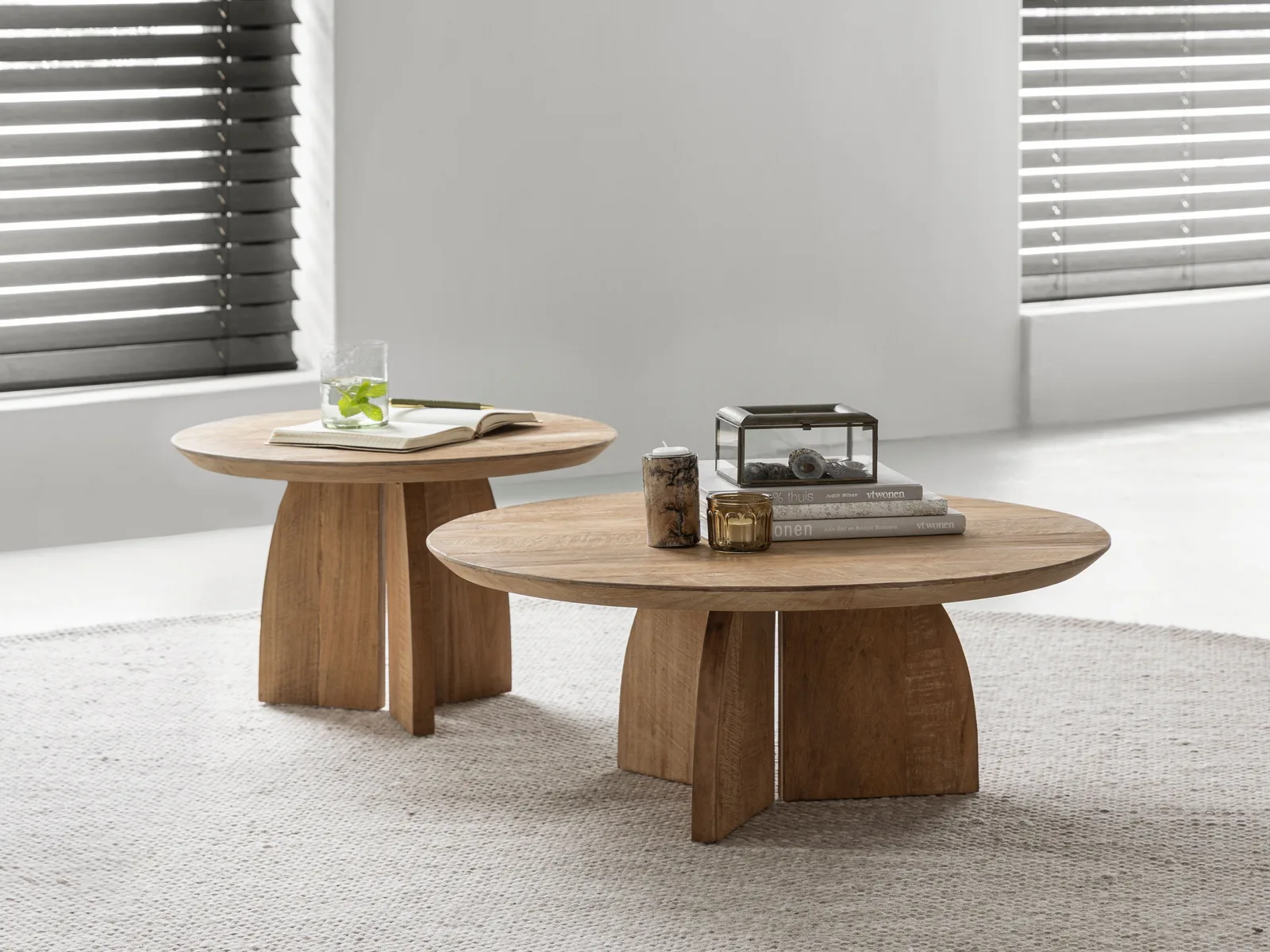 Zwei Couchtische Nova in einem hellen Wohnzimmer mit einem Teppich, Dekoration und einem offenen Buch - DTP Home