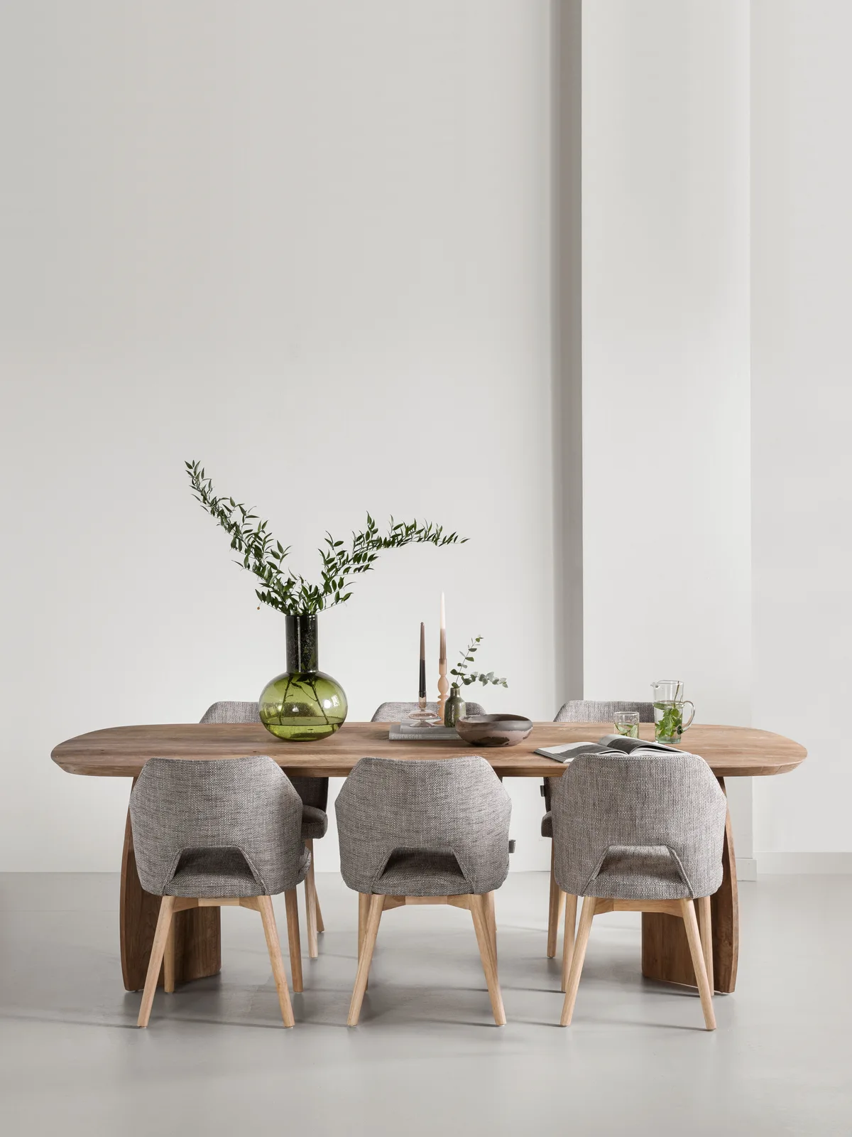 Der rechteckige Esstisch Nova in einem minimalistischen Studio-Setting, umgeben von sechs gepolsterten Stühlen - DTP Home