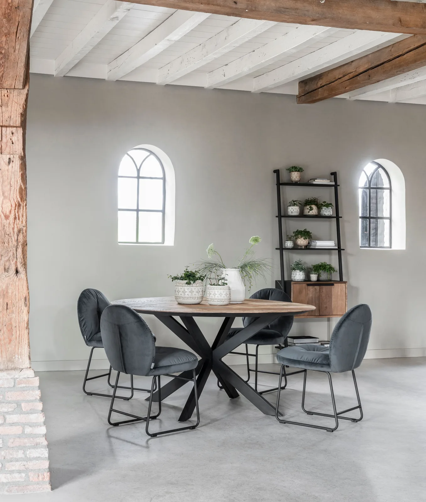 Runder Esstisch Shape in einem ländlichen Esszimmer mit grauen Wänden, Holzbalken und dunkelgrauen Stühlen - DTP Home