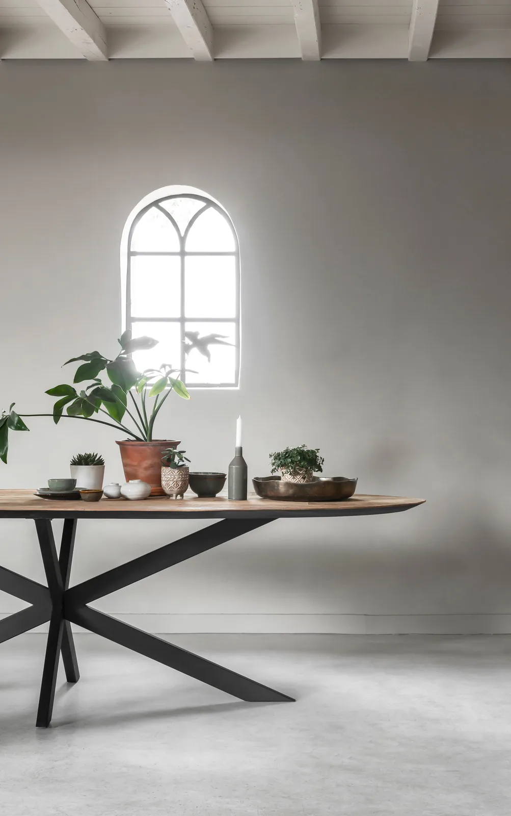 Esstisch Shape rund in einem hellen Raum mit einem Bogenfenster und verschiedenen Pflanzen und Accessoires - DTP Home