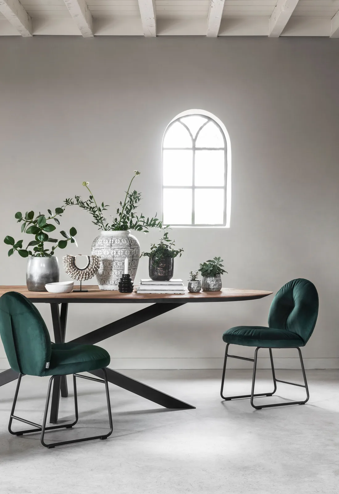 Runder DTP Home Esstisch Shape in einem hellen Studio mit zwei grünen Stühlen und Dekoration