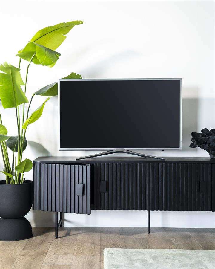 TV-Kommode Remi 4 Türen schwarz Mangoholz in einem hellen Wohnzimmer mit Pflanze und Fernseher darauf - Eleonora