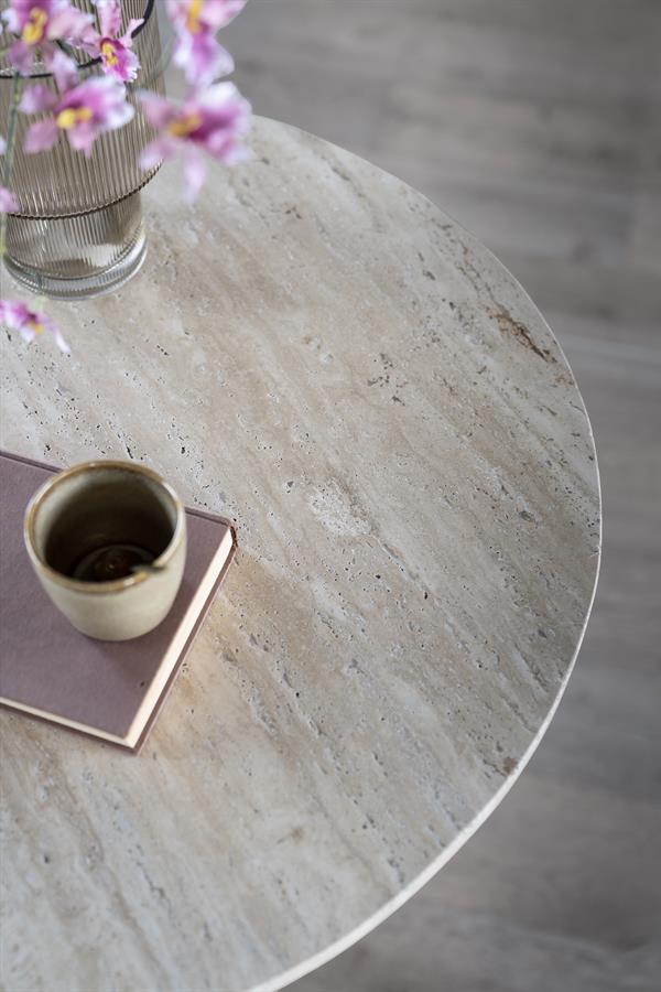 Detailaufnahme der runden Travertin-Tischplatte von Tisch Aime mit einem Buch und einer Tasse darauf - Eleonora