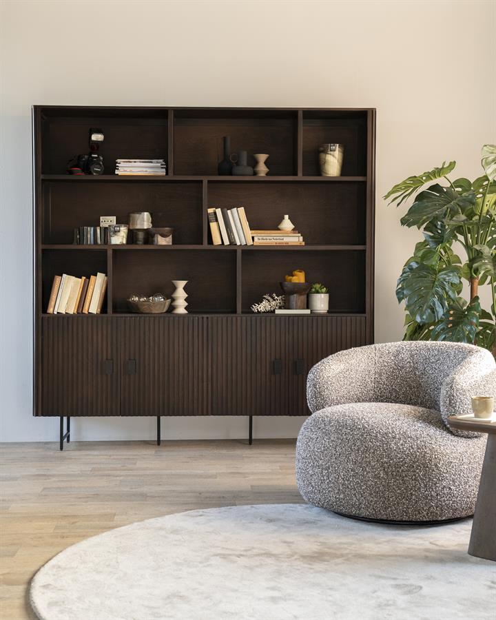 Wandschrank Remi schwarz Mangoholz in einem modernen Wohnzimmer mit Sessel und Pflanze - Eleonora