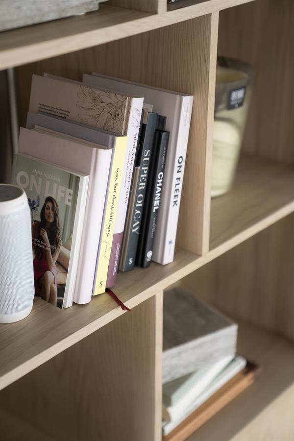 Detail des Bücherregals Harvey mit Büchern und Dekoration auf den Regalböden, aus schräger Perspektive fotografiert - Eleonora