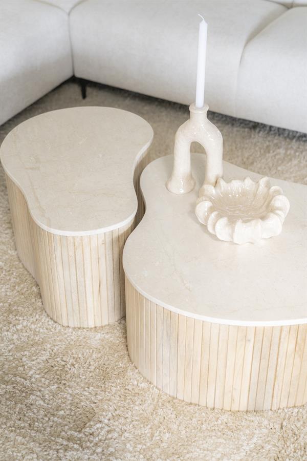 Der Couchtisch Kira small Mangoholz auf einem hellen Teppich, mit einem Kerzenständer und einer Schale darauf - Eleonora