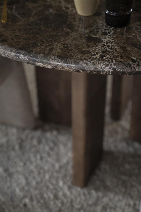 Detailaufnahme der marmorierten Platte des Esstisch Lando 127 cm Mangoholz, mit einem Teil des Holzbeins und Teppich - Eleonora