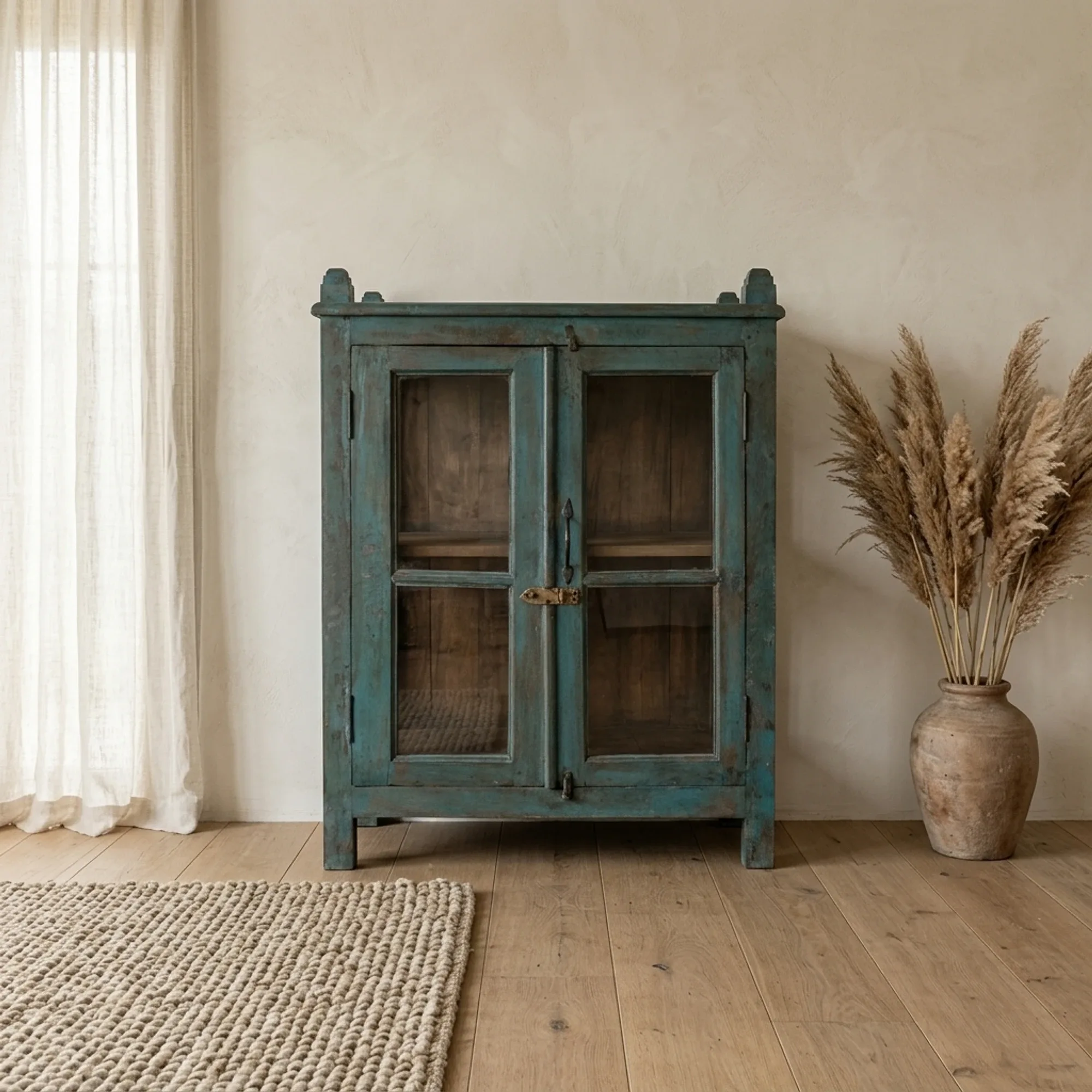 Kommode Indien Holz und Glas J17 in einem hellen Wohnzimmer mit einem Teppich und Pampasgras - Benoa
