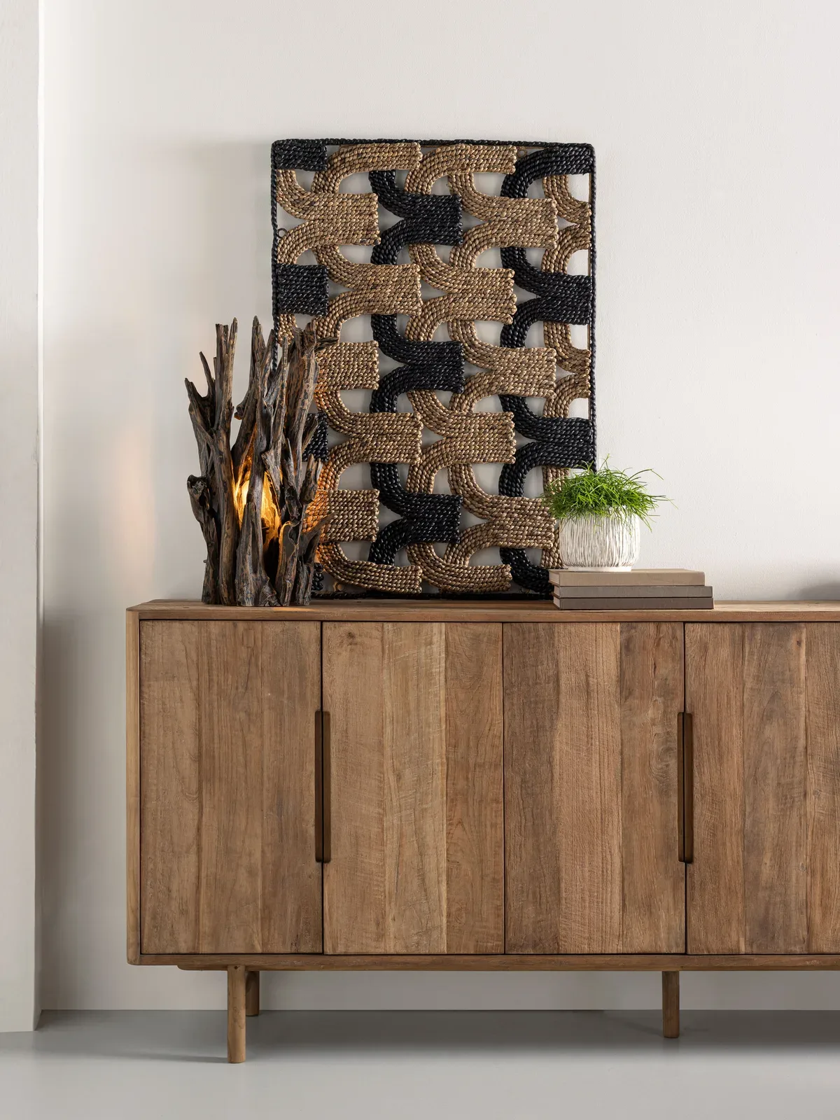 Kommode Bliss in einer Studio-Umgebung, mit einer Holzlampe und geflochtener Wanddekoration darüber - DTP Home