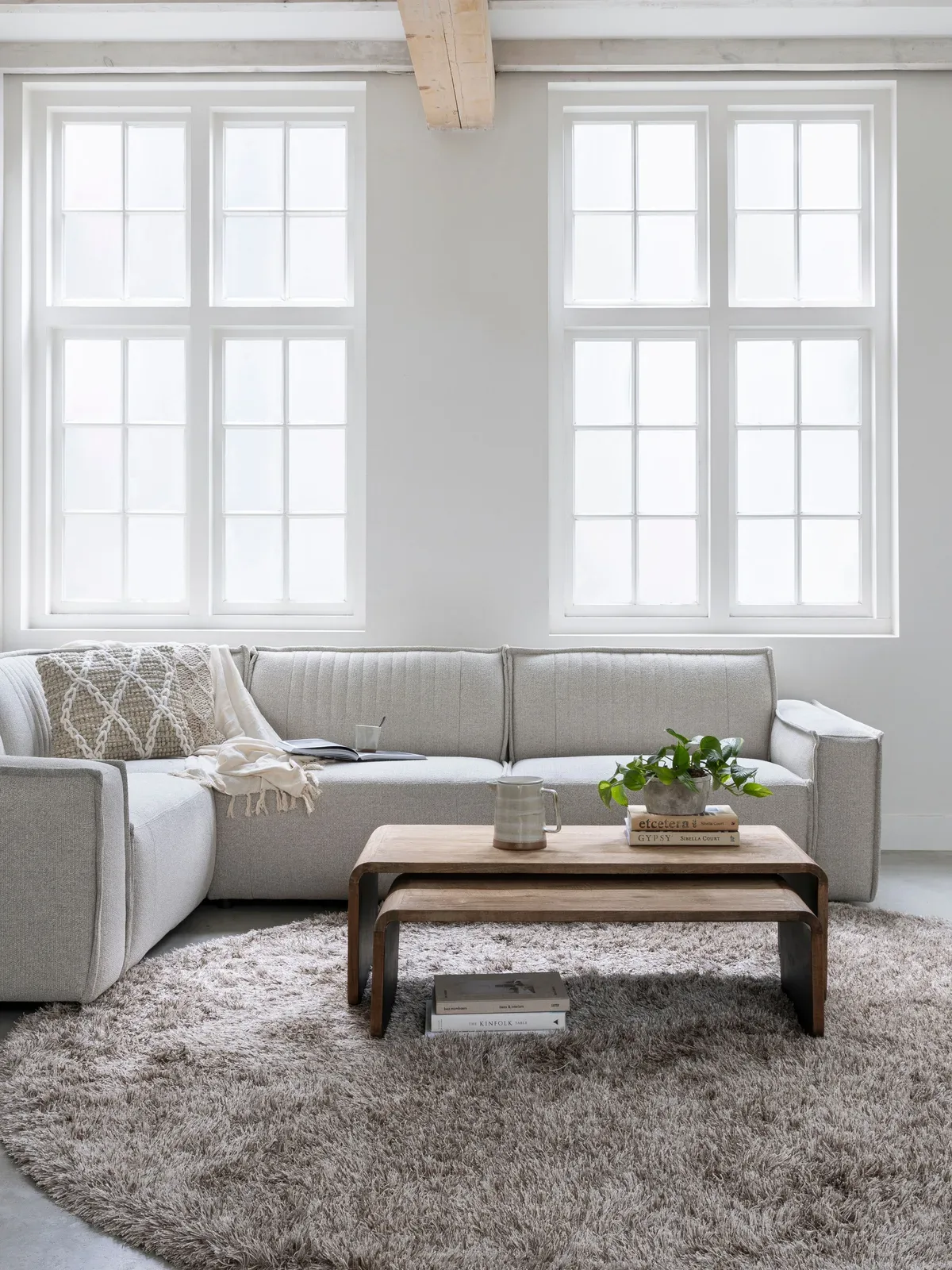 Couchtisch Evo in einem hellen Wohnzimmer mit einem beigen Ecksofa und einem runden Teppich - DTP Home