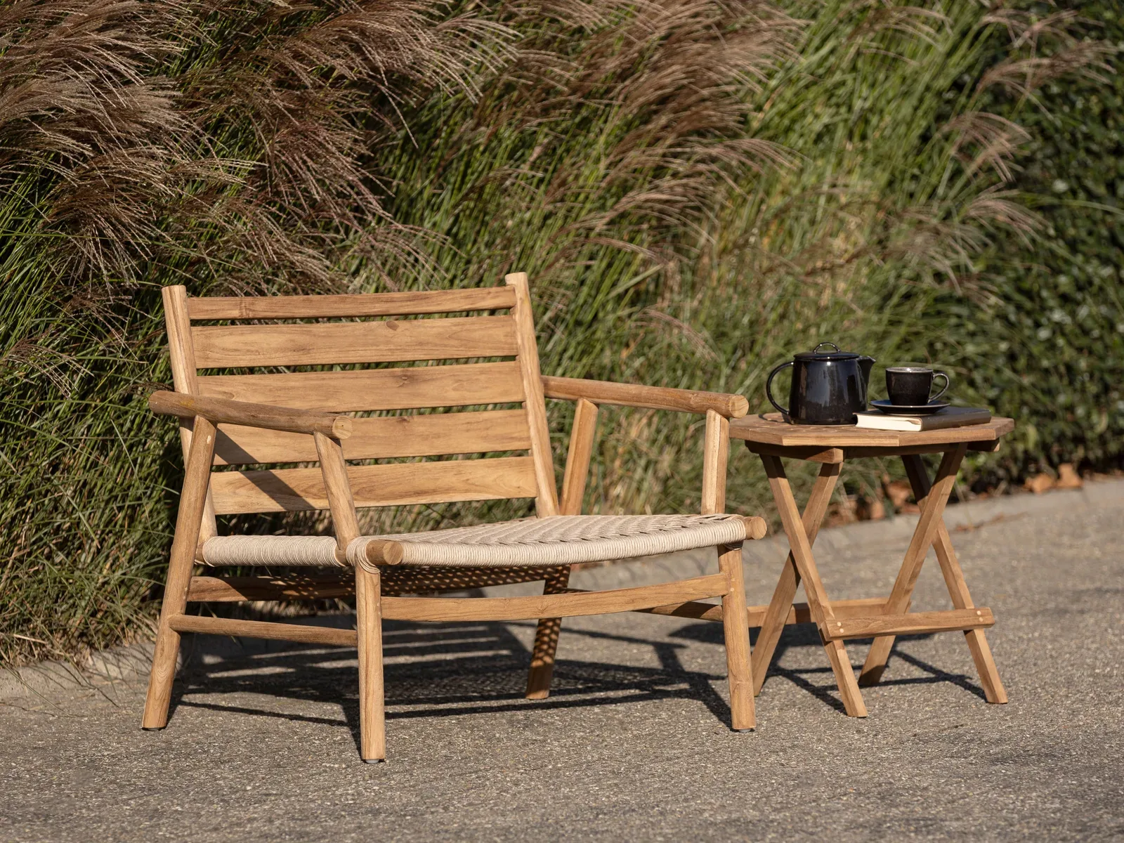Loungesessel Ono in einer Gartenumgebung mit einem Beistelltisch, Teekanne und Tasse - MUST Living
