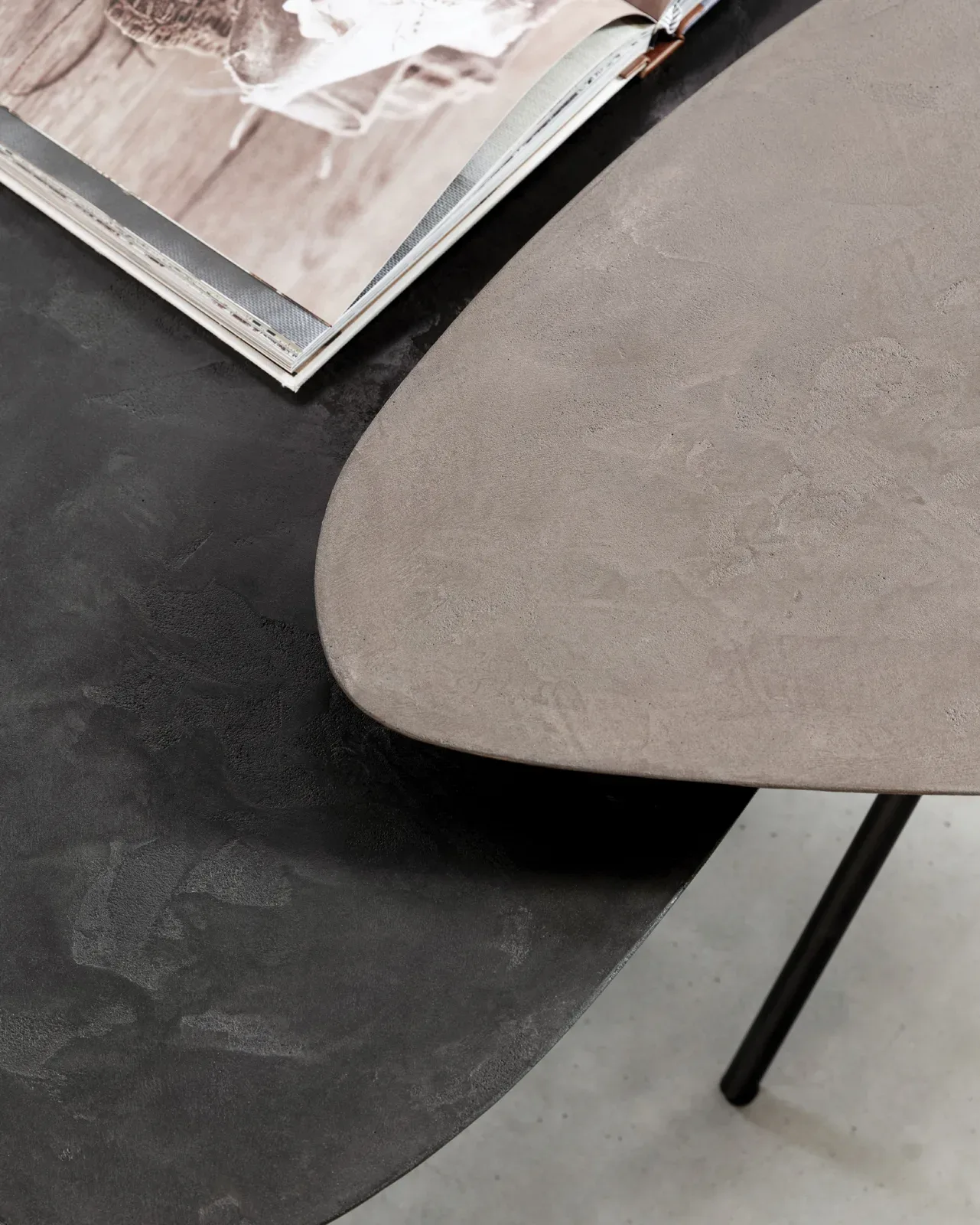 Detailaufnahme von zwei DTP Home Couchtischen Scala Plectro Earth, mit einer offenen Zeitschrift auf dem schwarzen Tisch