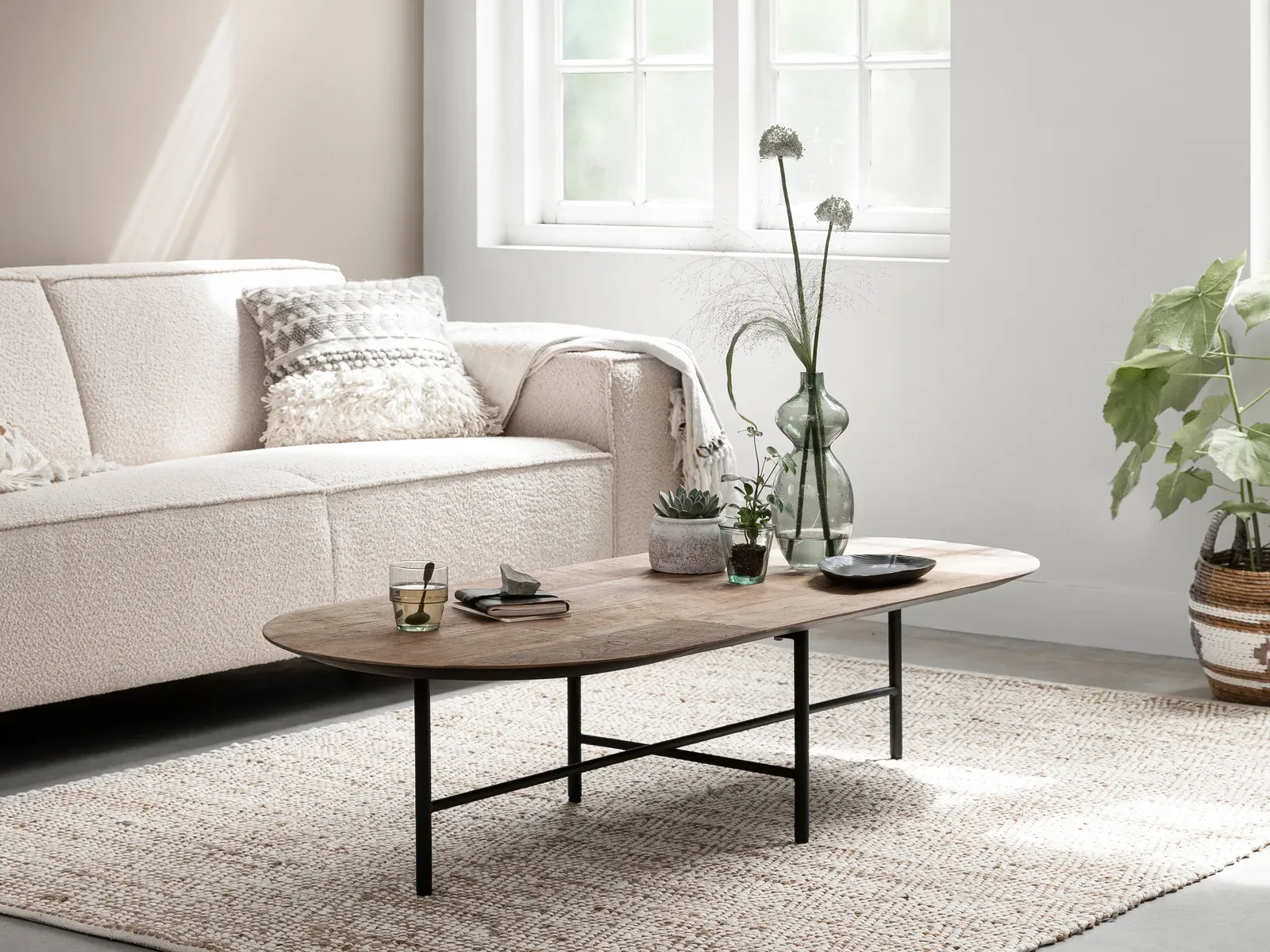 De Salontafel Soho in een lichte woonkamer met een bank, vloerkleed en planten - DTP Home