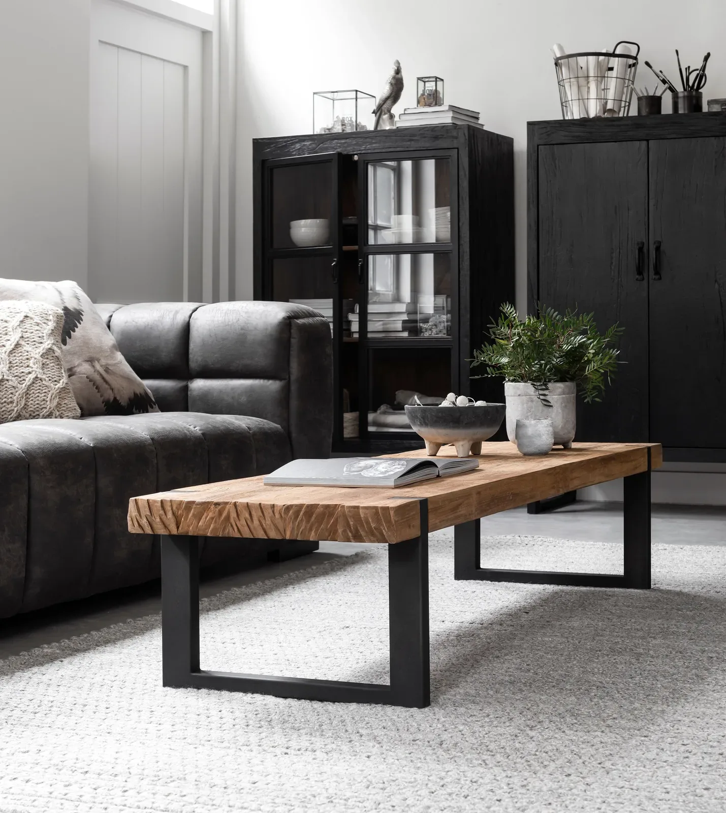 Der Couchtisch Beam in einem stimmungsvollen Wohnzimmer mit dunkelgrauem Sofa und schwarzen Schränken - DTP Home