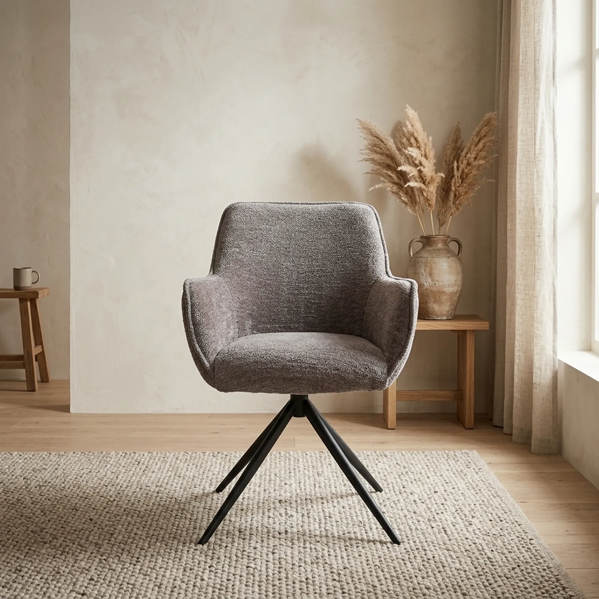 Der Fondo Sessel in Stoff Mona 464 Cement Grey, drehbar, steht auf einem Teppich in einem stimmungsvollen Studio-Setting - Tower Living