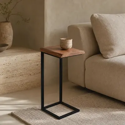 Deze Live Edge bijzettafel van het Mokana huismerk combineert een warm blad van massief acaciahout met een slank zwart m