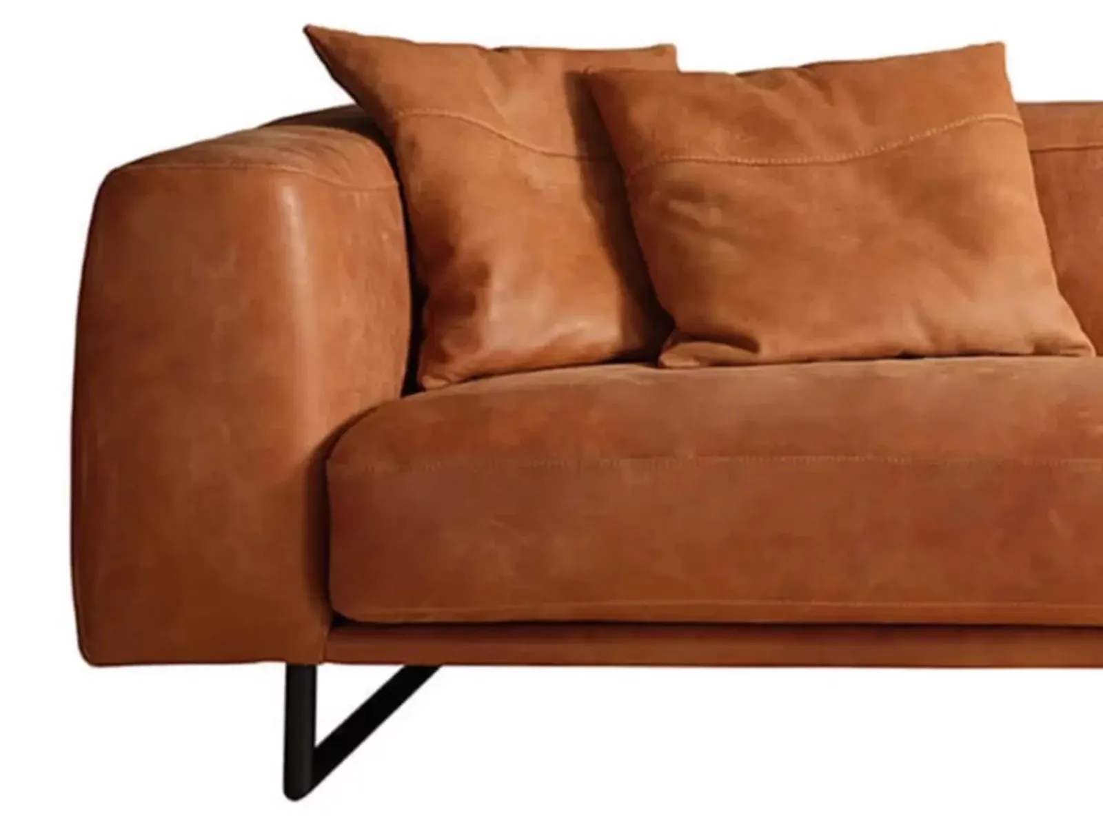 Detailansicht des Sofa Merida mit Armlehne, zwei Kissen und einem Teil des schwarzen Fußes - Zitform