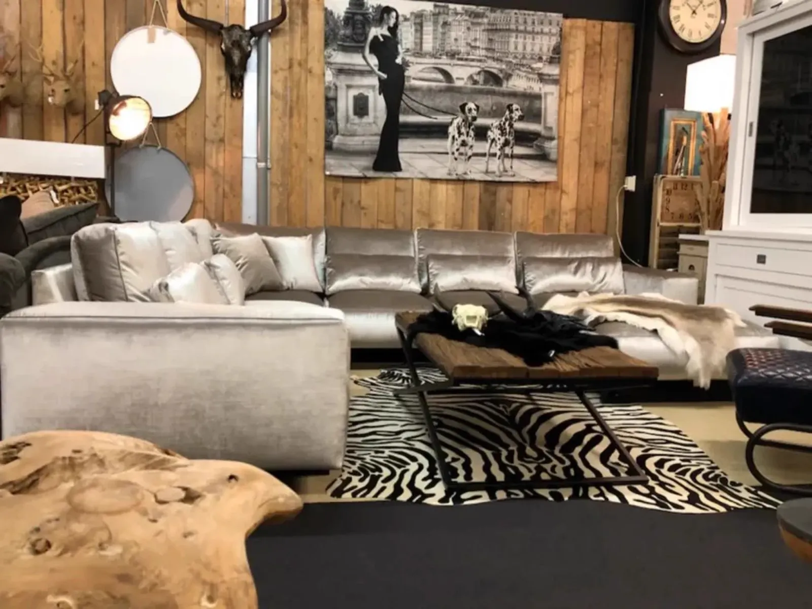 Ecksofa Genadi Velours in einem stimmungsvollen Wohnzimmer mit Holzwand und Zebra-Teppich