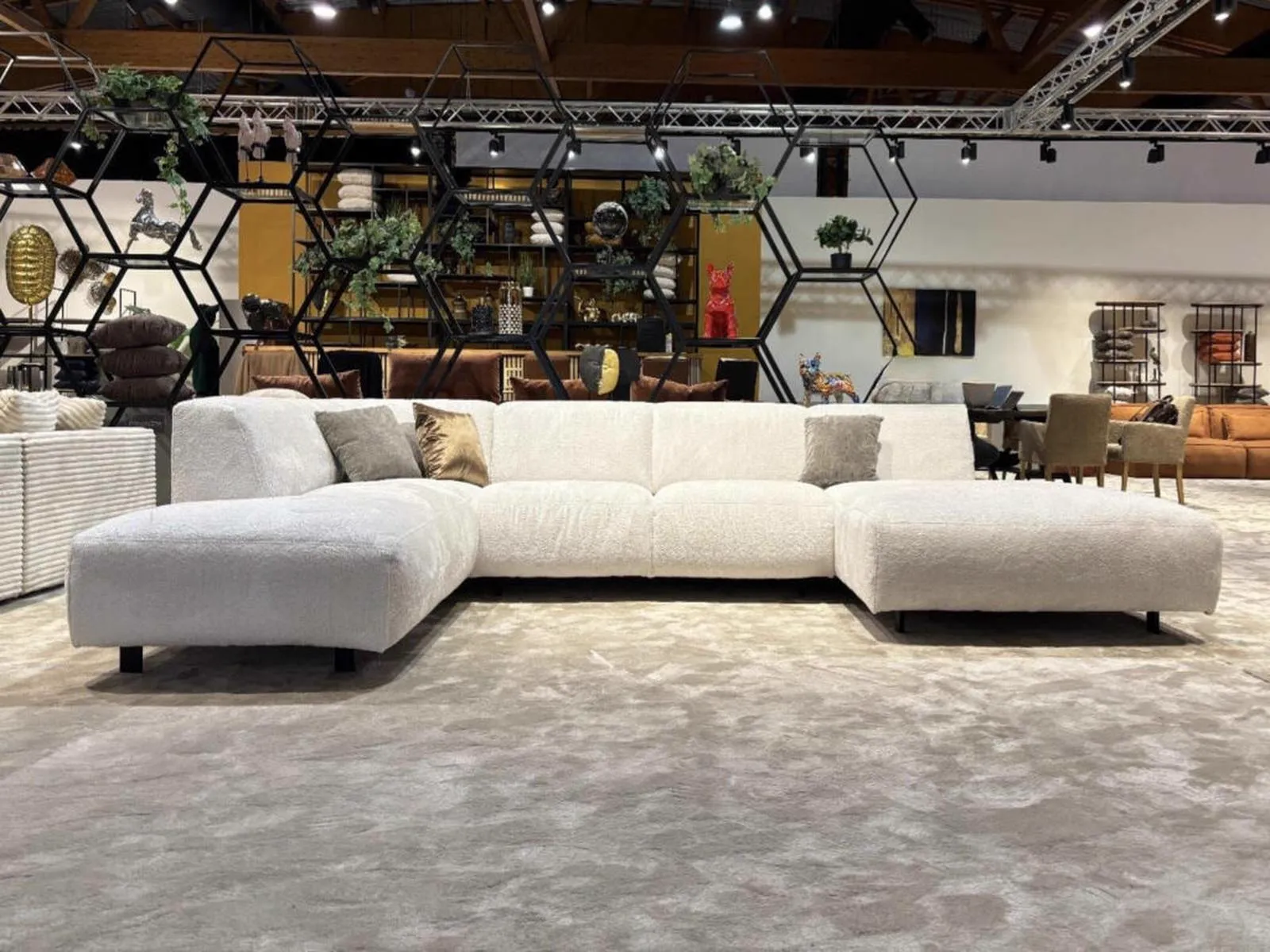 Ecksofa Konstantinopel in einem großen Ausstellungsraum, umgeben von dekorativen Regalen und anderen Möbeln - Primavera