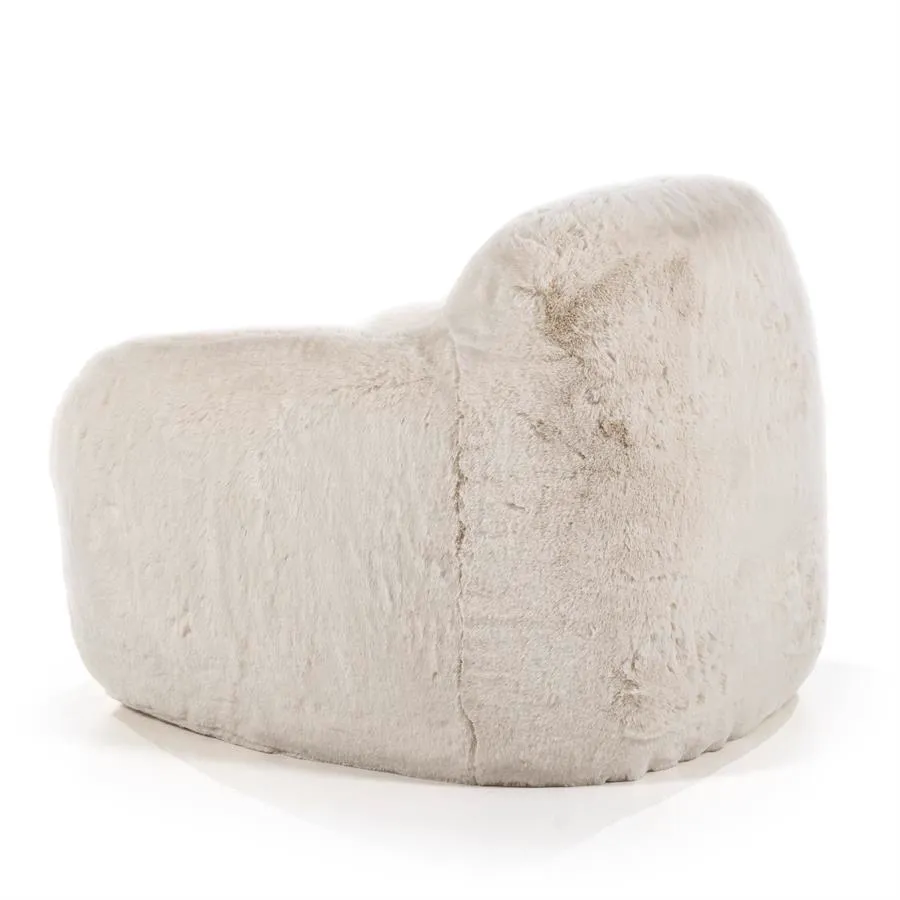 Der beige Hug Sessel von By-Boo, ein weicher Sessel mit pelziger Textur, auf weißem Hintergrund