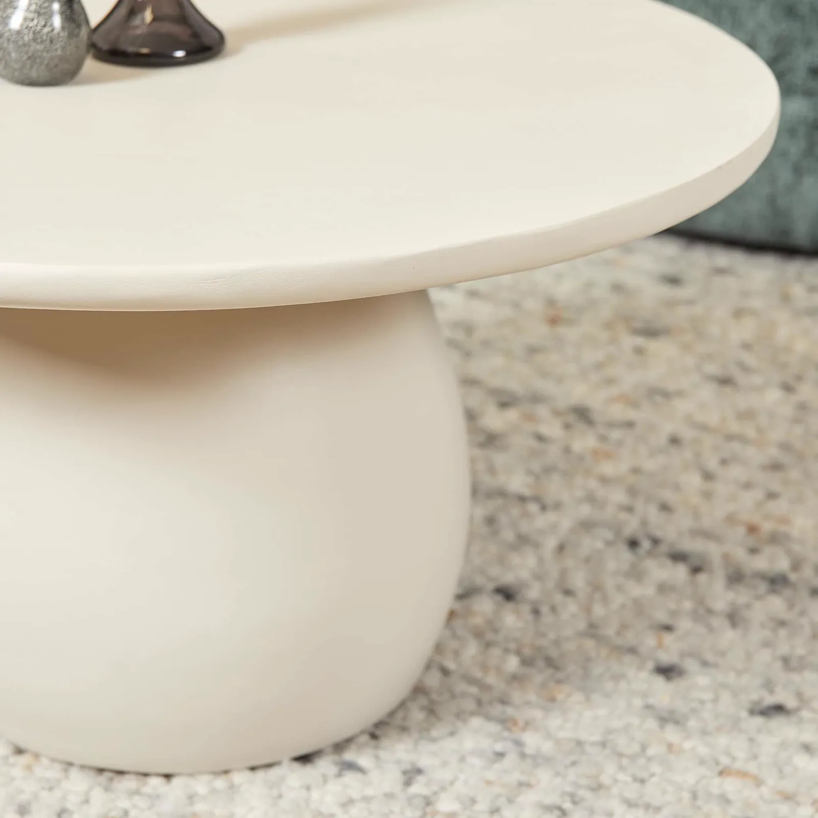 Nahaufnahme des Couchtisch Mosi, mit der runden Form und dem bauchigen Bein, auf einem Teppich - Starfurn