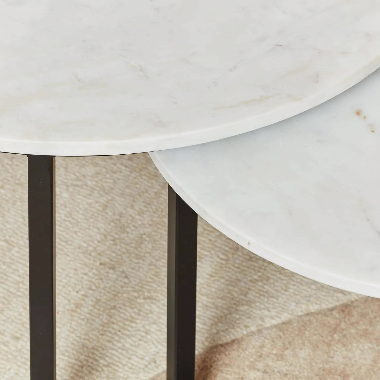 Detailopname van de twee ronde bladen van de Salontafel Nova White marble, met de zwarte poten eronder zichtbaar - Starfurn