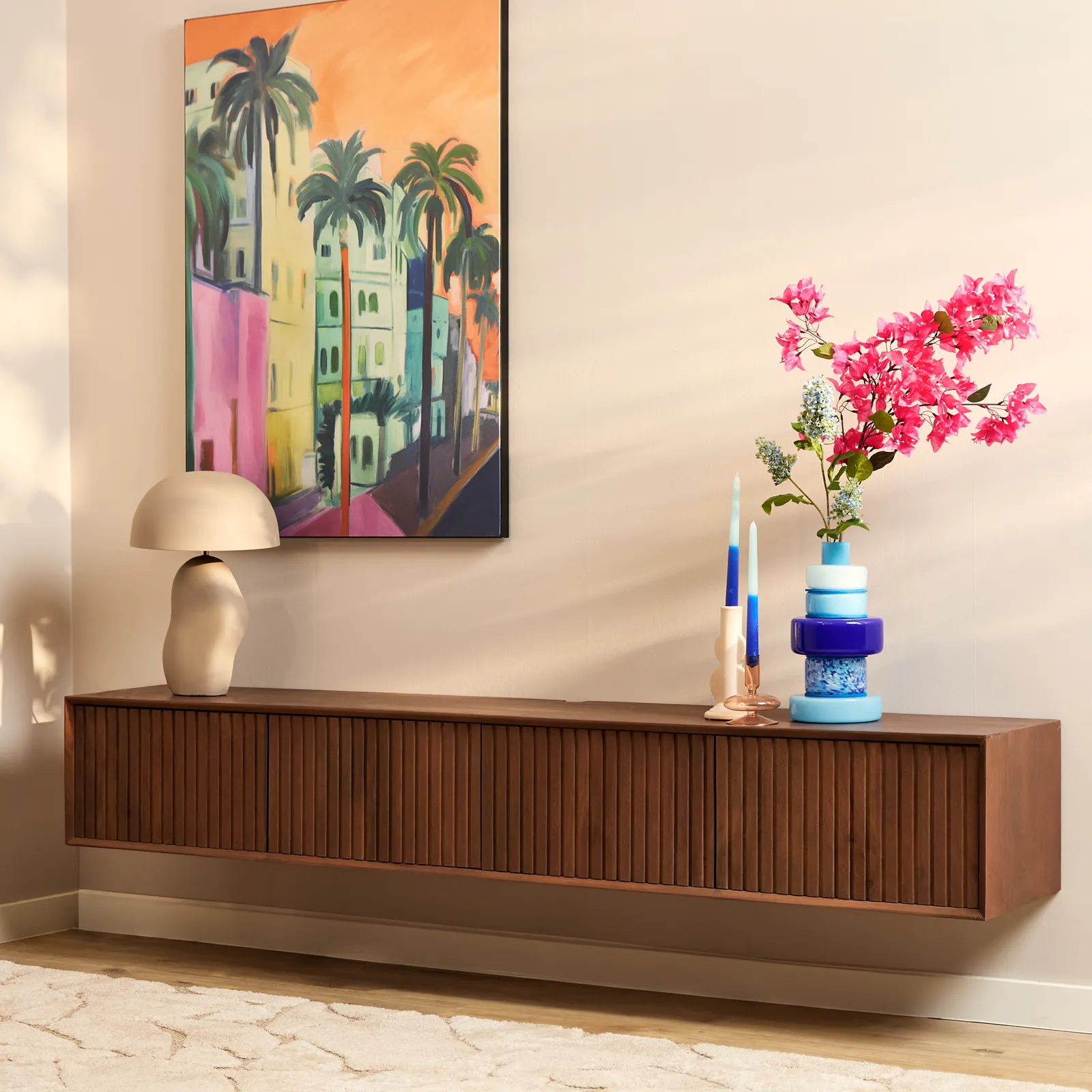 Zwevend tv meubel Madison Sand in een woonkamer, met een lamp en decoratie erop, vanuit een laag standpunt gefotografeerd - Starfurn