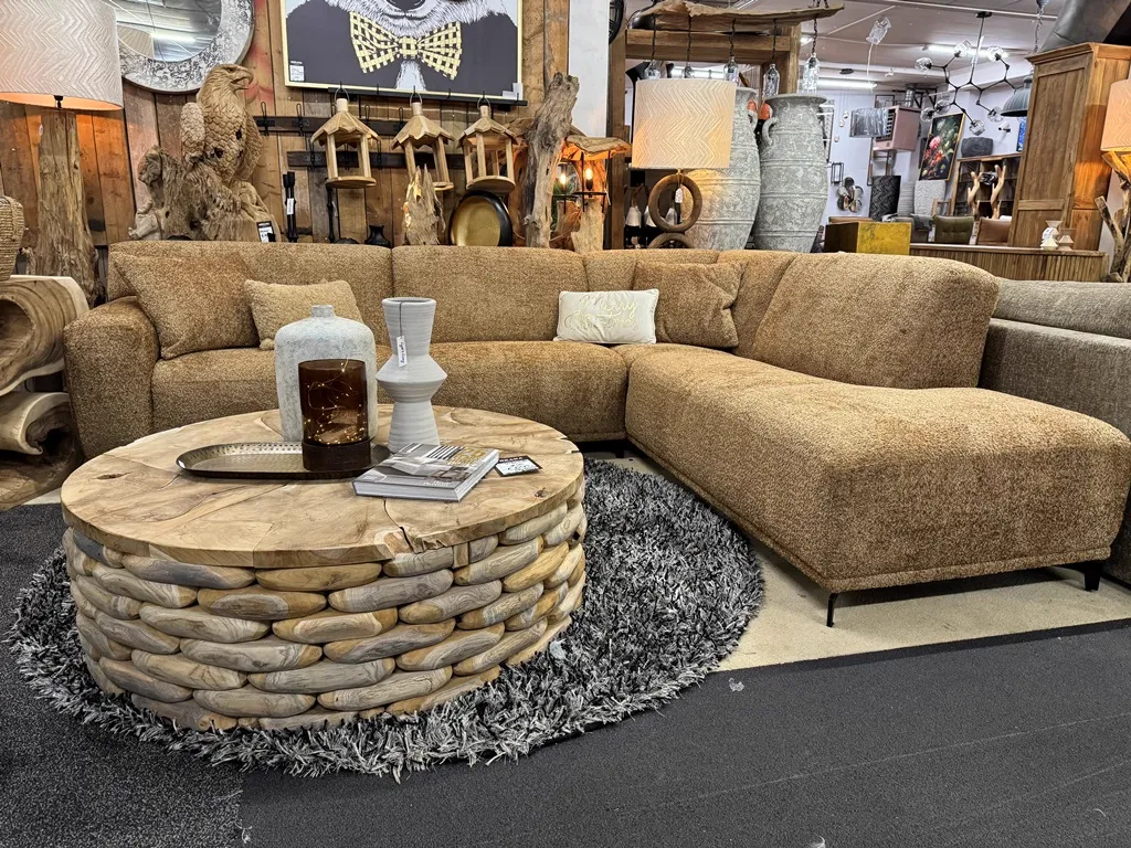 Das Ecksofa Shelby in einem stimmungsvollen Wohnzimmer-Arrangement mit einem Couchtisch aus Holz und Teppich - Zitform