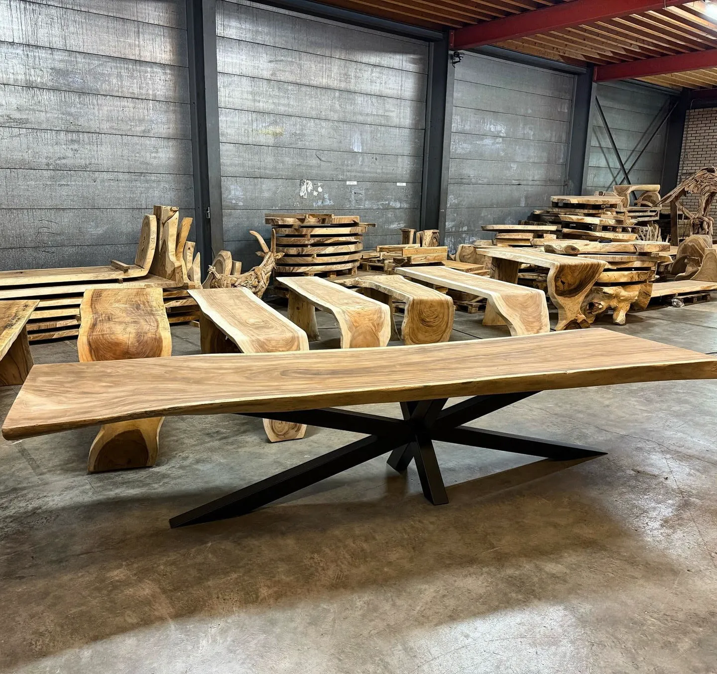 Baumstammtisch Suarholz mit Spinnenbein, aus der Nähe in einem Lager voller Holzprodukte fotografiert - World of Brosi