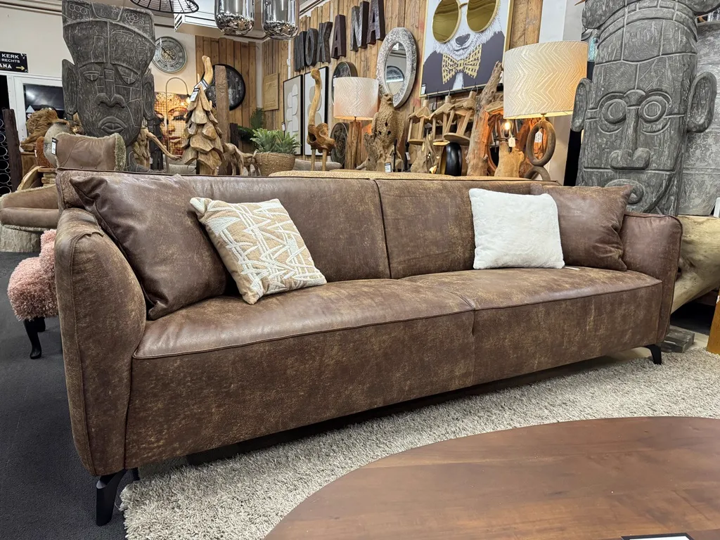 Sofa Globe Africa Leder in einer stimmungsvollen Umgebung mit Kissen und Dekoration, aus einer niedrigen Perspektive fotografiert - Zitform