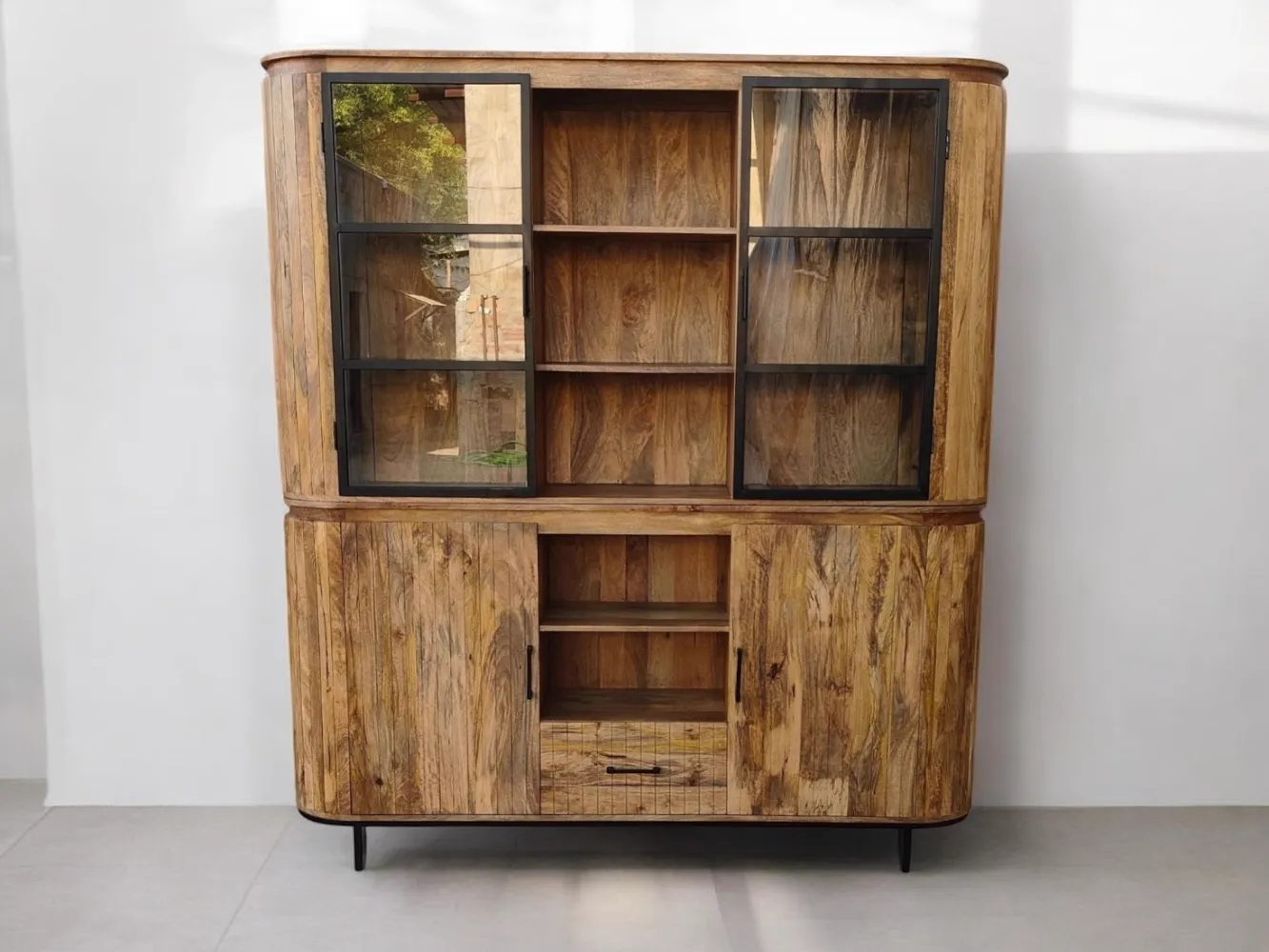 Vitrinekast Oxford in een studio, van voren gefotografeerd, met glazen schuifdeuren en open vakken - Mokana Furniture