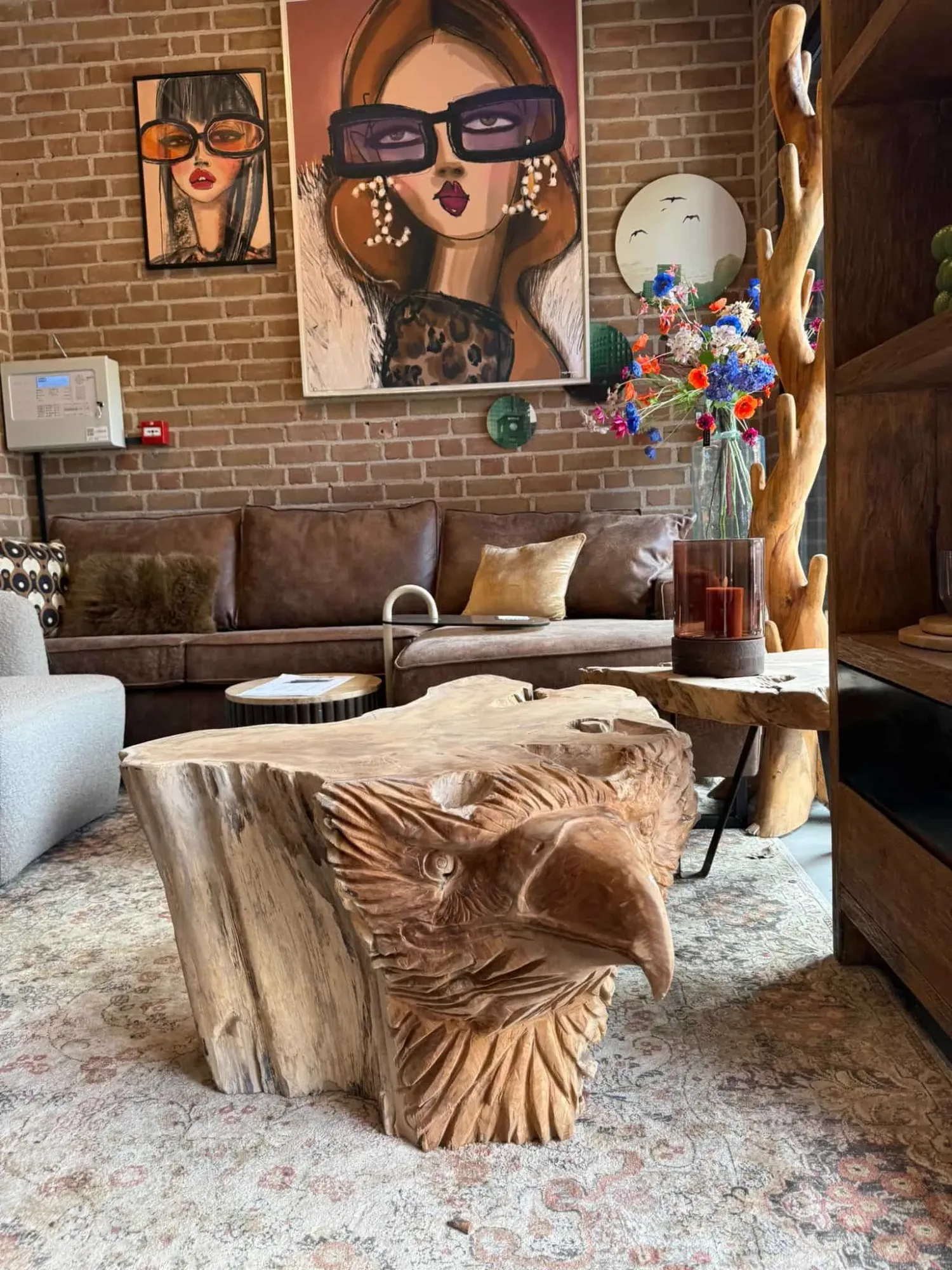 Couchtisch Eagle Teak Unique in einem stimmungsvollen Wohnzimmer mit braunem Sofa und Ziegelwand - World of Brosi