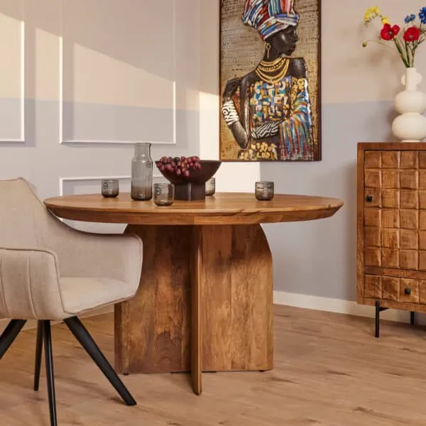Der runde Esstisch Tense 130 cm in einem stimmungsvollen Esszimmer mit Dekoration und einem Stuhl