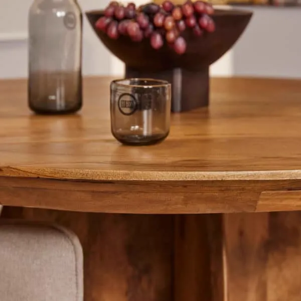 Detailaufnahme des Esstisch Tense, mit einer Glasflasche, Glas und Obstschale mit Trauben darauf