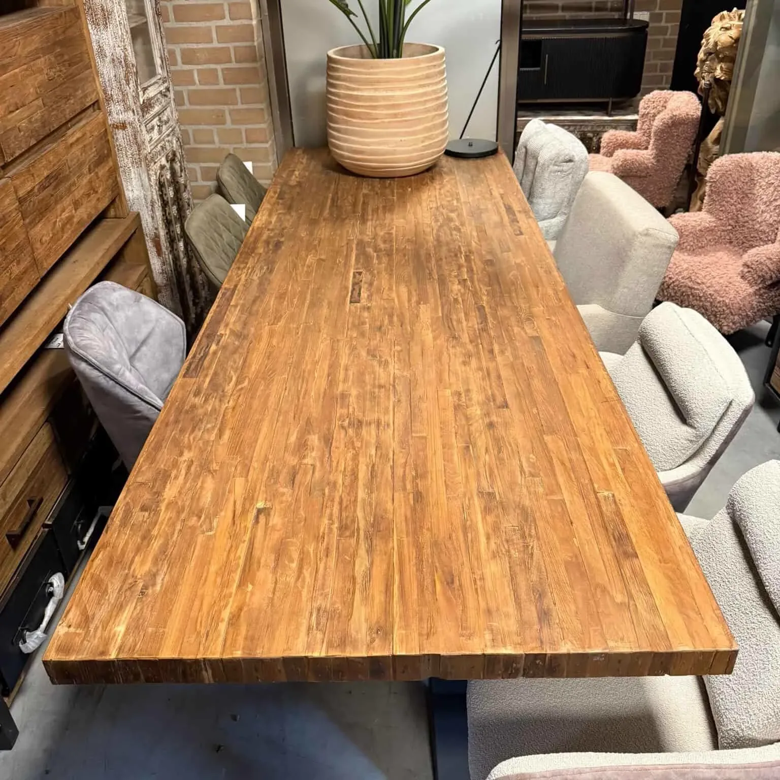 Donny Teakholz-Esstisch Massiv 280 cm in einem stimmungsvollen Showroom mit Stühlen und anderen Möbeln - World of Brosi