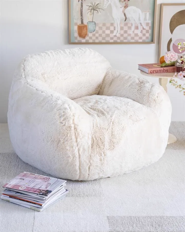 Der beige Hug Sessel in einem hellen Wohnzimmer mit einem Gemälde und einem Beistelltisch - By-Boo