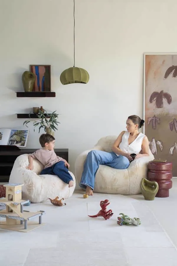 Der Hug - beige Sessel in einem hellen Wohnzimmer mit einer Frau und einem Kind, die darauf sitzen, von vorne fotografiert - By-Boo