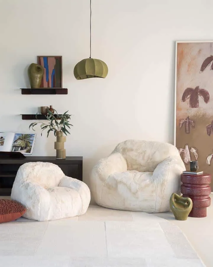 Zwei Hug - beige Sessel in einem hellen Wohnzimmer mit einer Hängelampe und Wandkunst - By-Boo