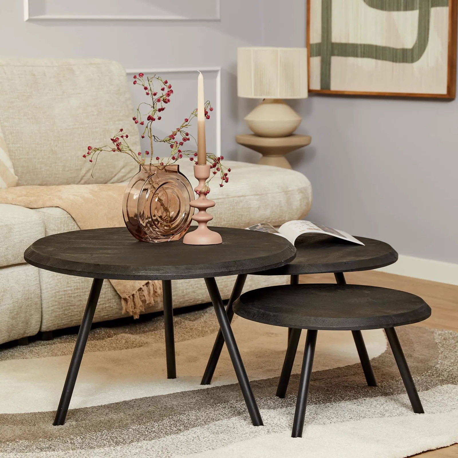Couchtisch Ohio Black, ein Set aus drei schwarzen runden Tischen, in einem hellen Wohnzimmer mit Sofa und Teppich - Starfurn