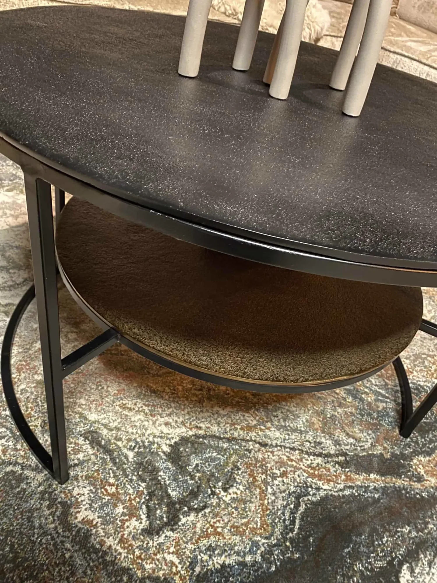 Nahaufnahme des Couchtisch Lecia, mit Fokus auf die zwei runden Platten und die Metallbeine auf einem Teppich - Starfurn