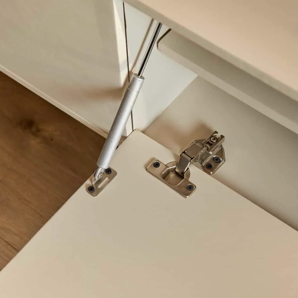 Detail van het zwevend tv meubel Vision Sand, met een open klep en zicht op de scharnieren en gasveer - Starfurn