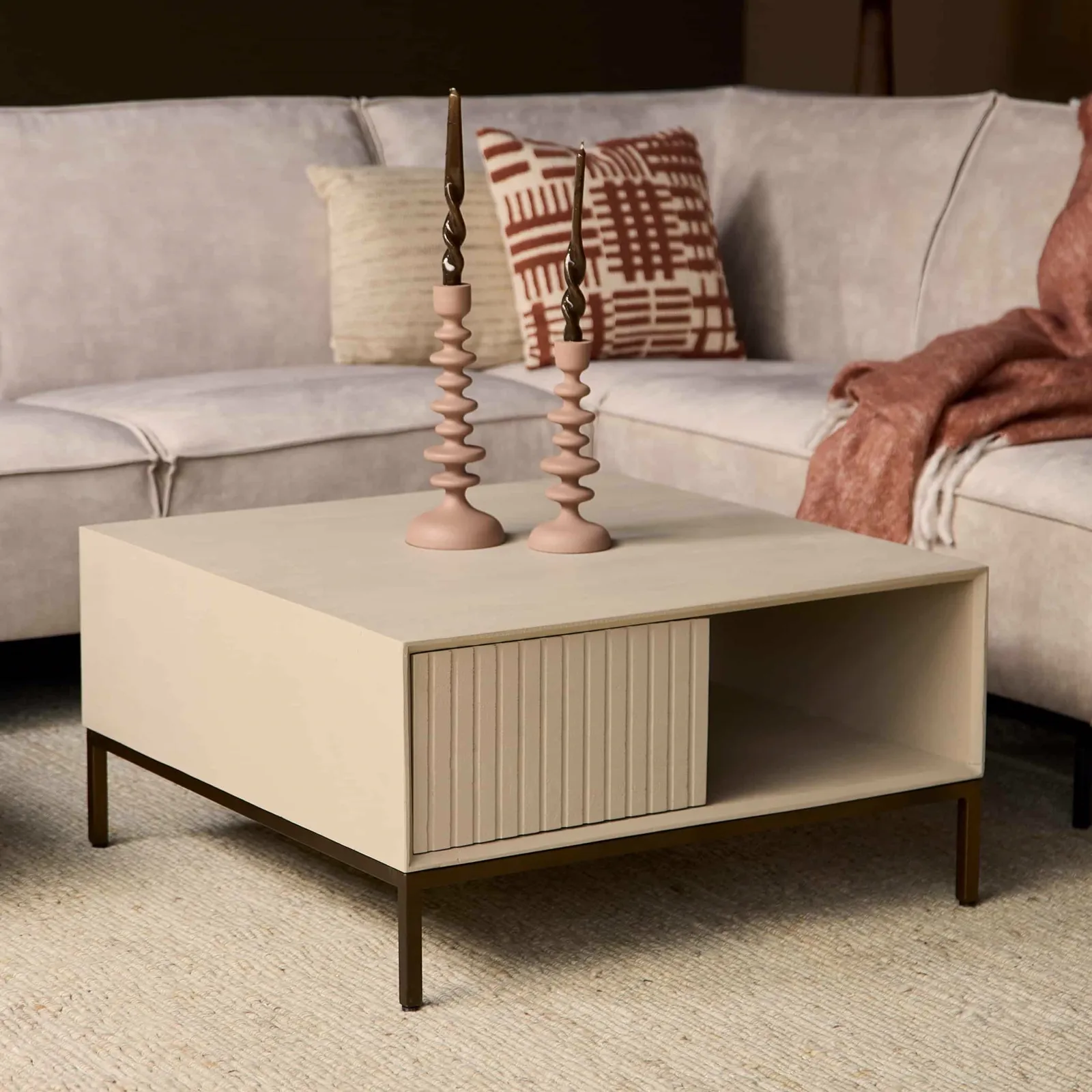 Couchtisch Madison Sand, quadratisch, in einem modernen Wohnzimmer mit Sofa, Kissen und Kerzen - Starfurn