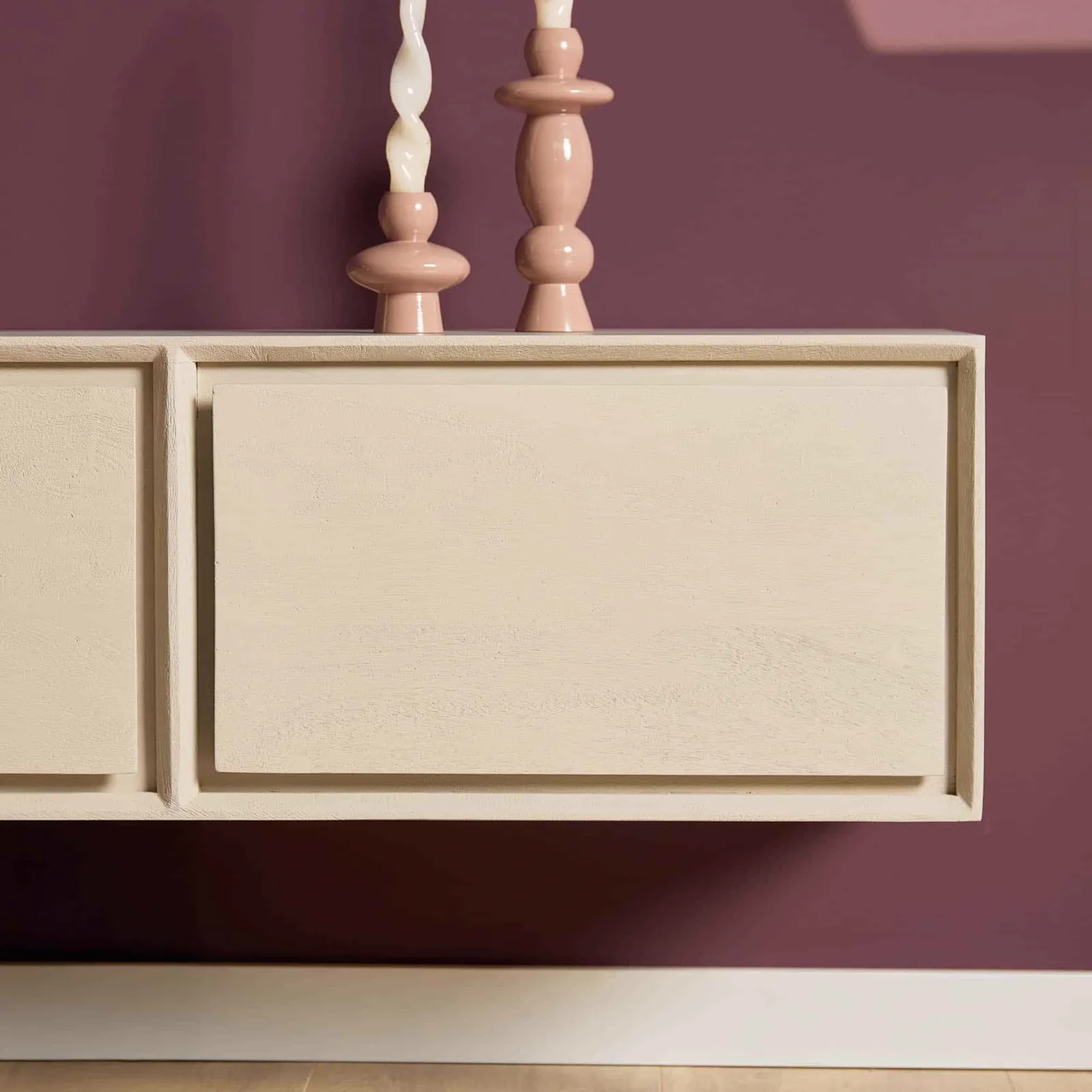 Schwebendes TV-Möbel Ambiance Sand, 160 cm, mit zwei rosa Kerzenhaltern vor einem dunkelvioletten Hintergrund - Starfurn