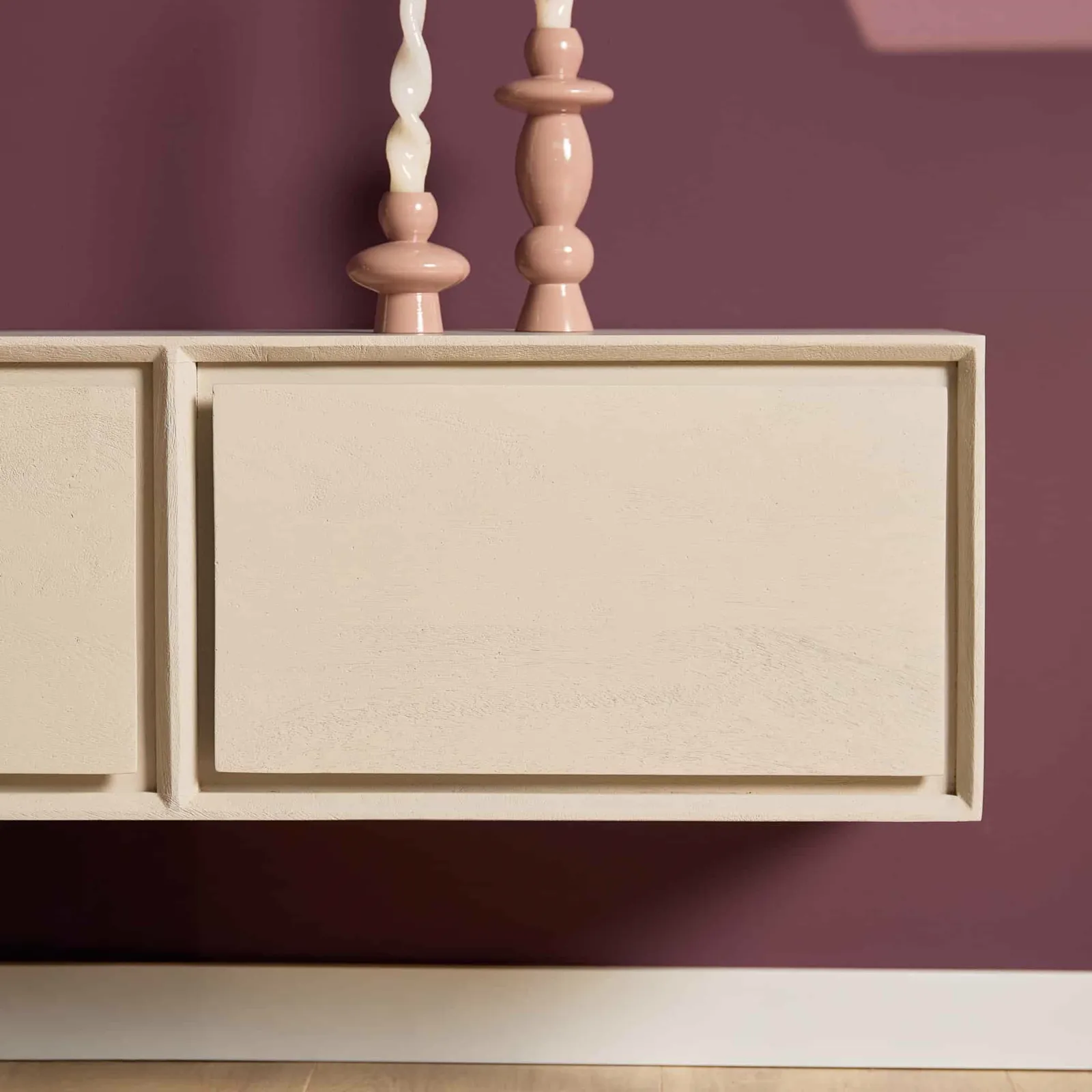 Detailaufnahme des schwebenden TV-Möbel Ambiance Naturel, mit zwei rosa Kerzenhaltern darauf vor einer lila Wand - Starfurn