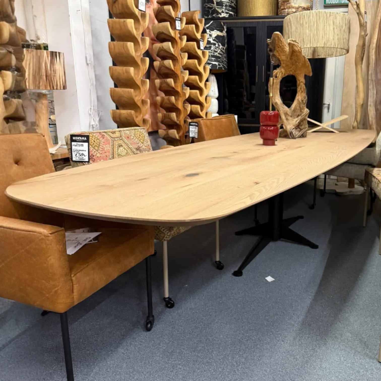 Langer Esstisch Ellips | Bootsmodell | 380cm Eiche in einem Ausstellungsraum mit Holzdekoration und einem braunen Stuhl