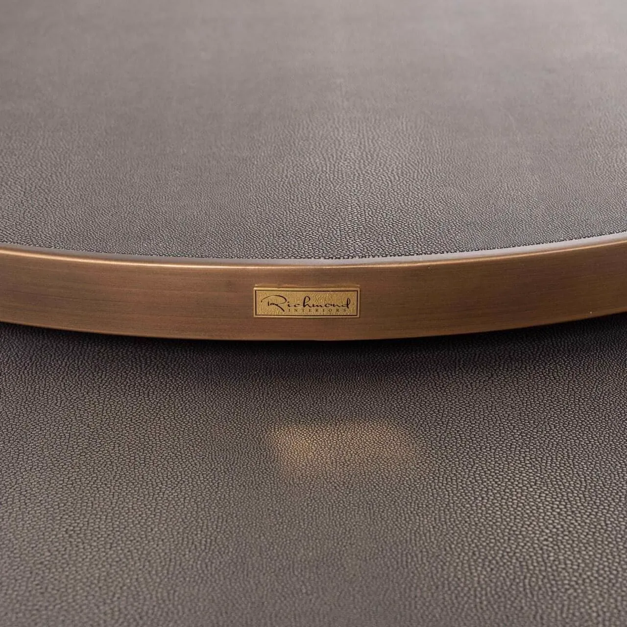 Detail des Couchtisch Bloomville brass shagreen, mit dem Markenetikett am Messingrand - Richmond Interiors