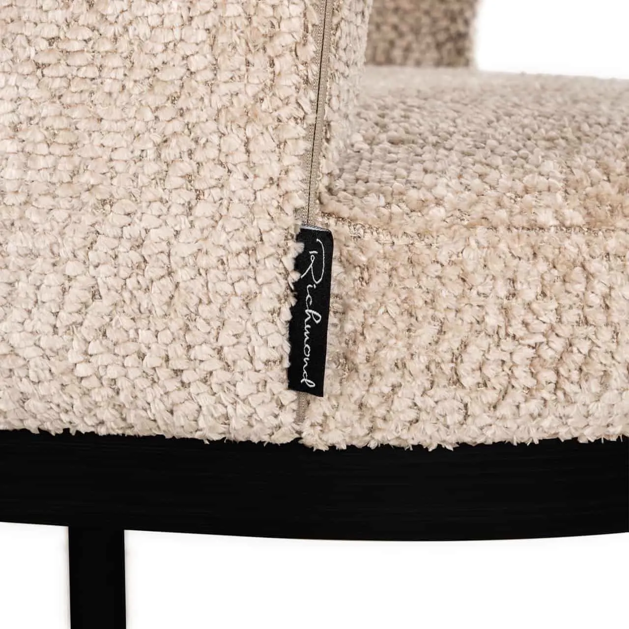 Detail des Esszimmerstuhls Ellis lovely beige, mit Nahaufnahme des beigen Bouclé-Stoffs und einem Markenetikett - Richmond Interiors