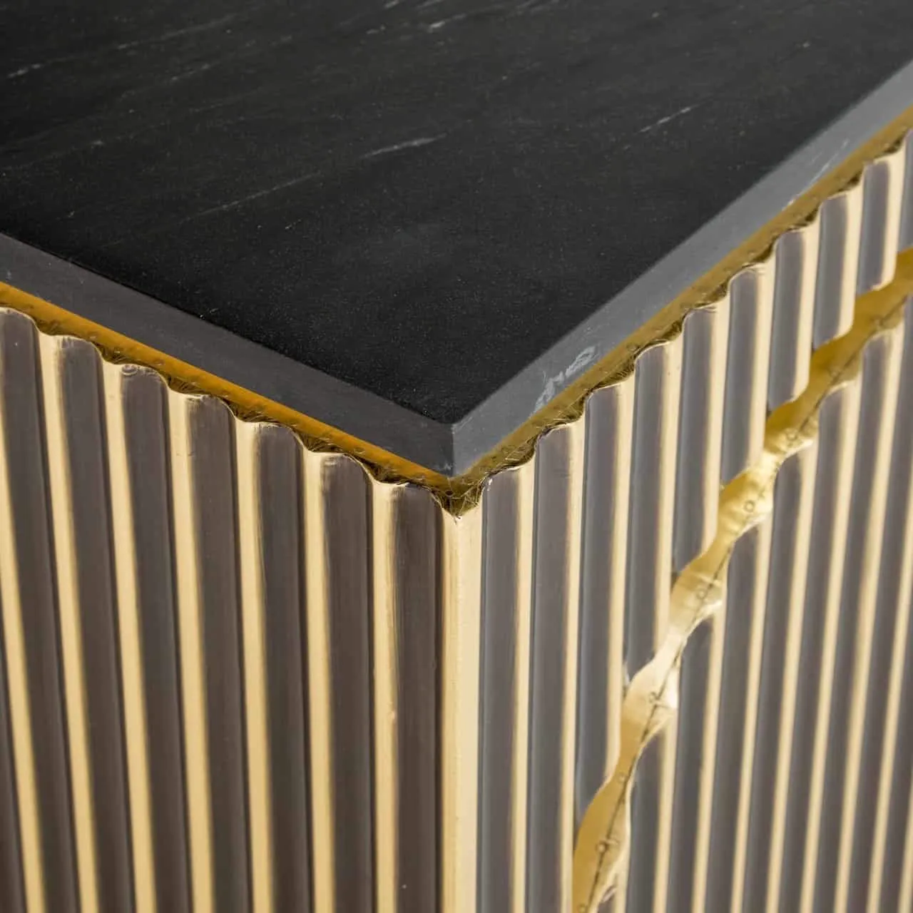Detailaufnahme der schwarzen Marmorplatte und der goldfarbenen vertikalen Lamellen des Sideboards Les Arcs brushed gold - Richmond Interiors
