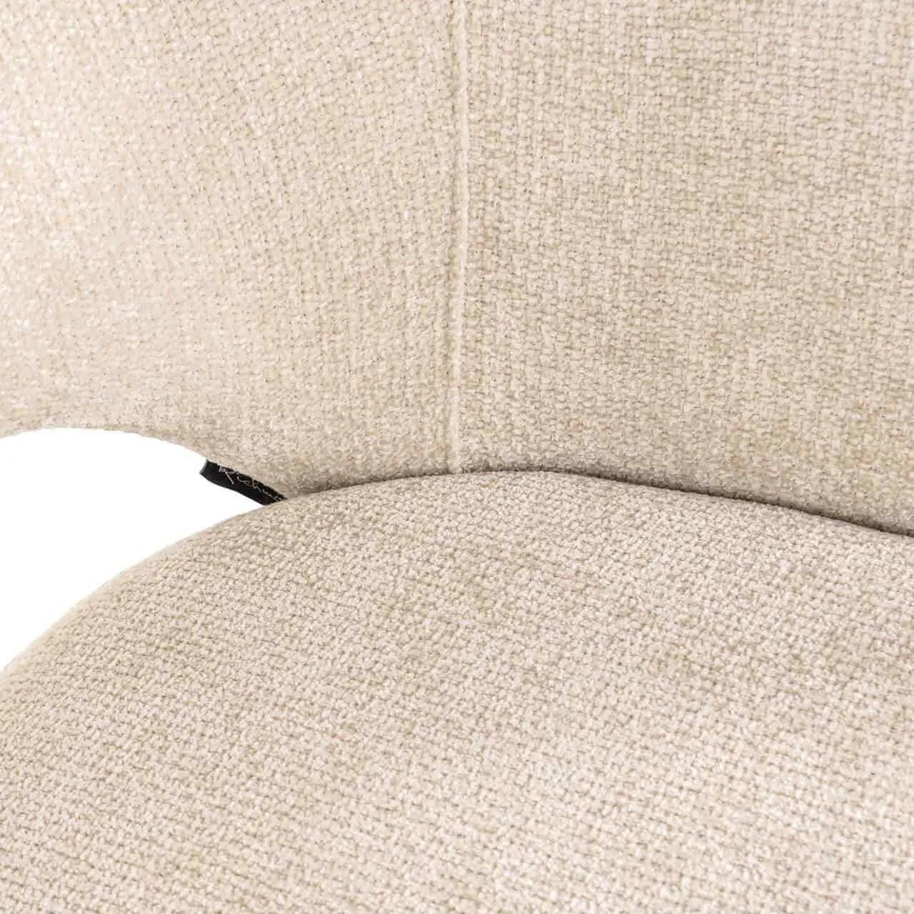 Nahaufnahme der Sitzfläche und Rückenlehne des Essstuhls Kenzi cream unicorn, mit der Textur des Stoffes und einem schwarzen Etikett - Richmond Interiors